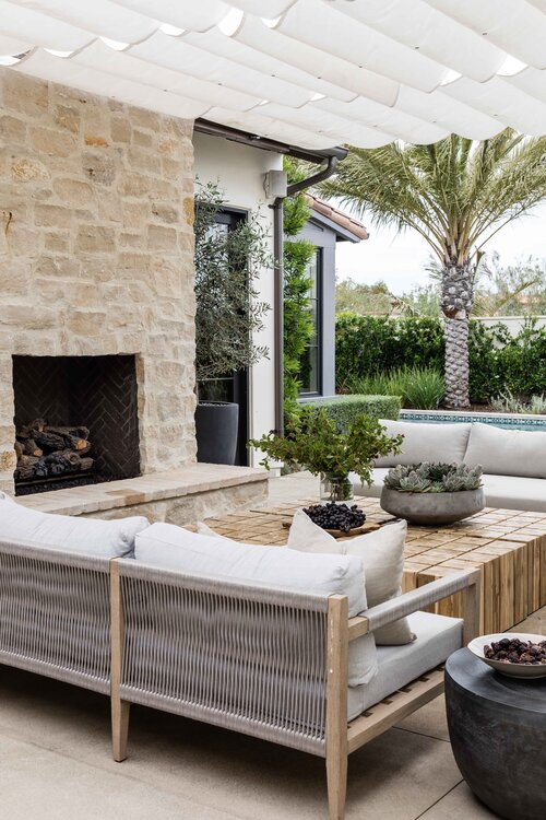 Love this beautiful covered patio and outdoor sitting and lounging area with a stone fireplace - patio ideas - covered patio design - modern coastal style - pure salt