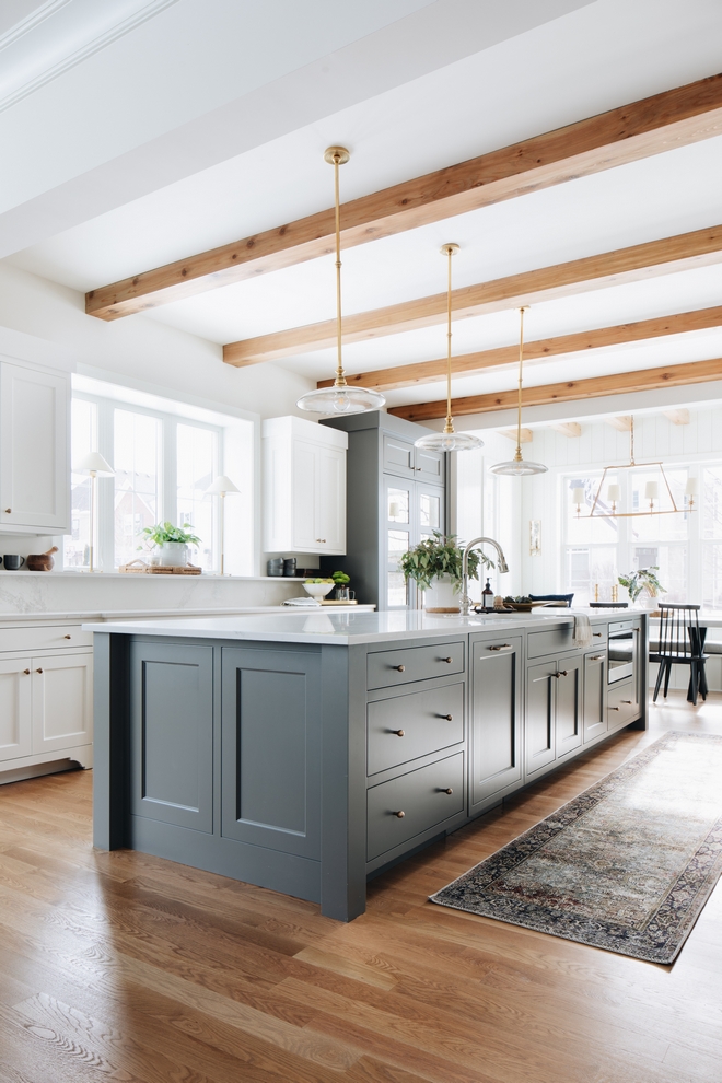 Love this beautiful kitchen design with wood beams, a gray blue kitchen island and modern pendant lights - kitchen ideas - kitchen remodel - kitchen decor - coastal interiors 