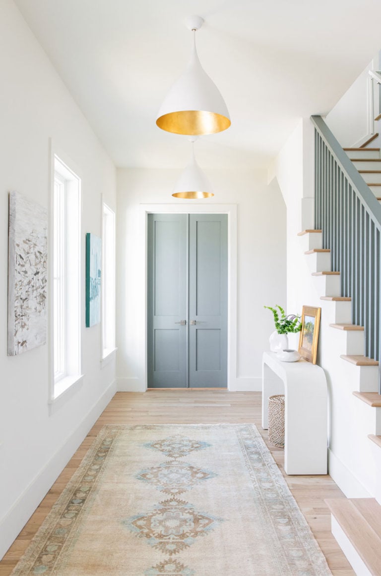 Love this beautiful entryway with a vintage Turkish runner, blue doors and modern white and brass cone pendant light - entryway ideas - entryway rug - entryway decor - entryway lighting