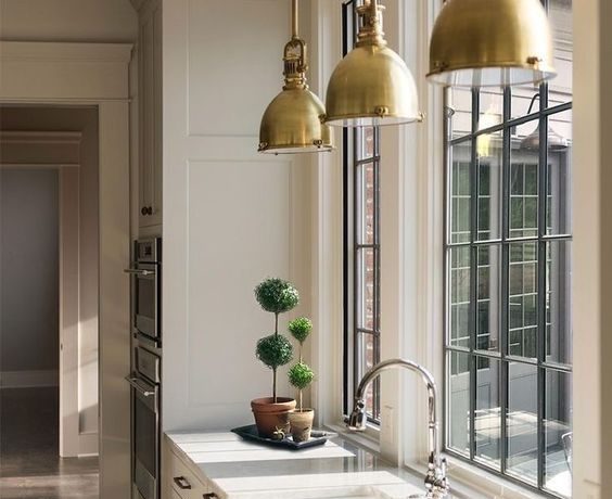 Love this beautiful kitchen design with black framed windows and brass pendant lights