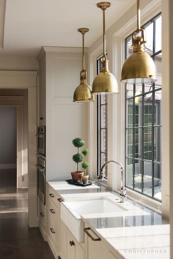 Love this beautiful kitchen design with black framed windows and brass pendant lights