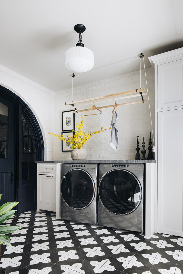 Luxury black and white laundry room with patterned tile floor. Top interior design and home decor trends for 2022 