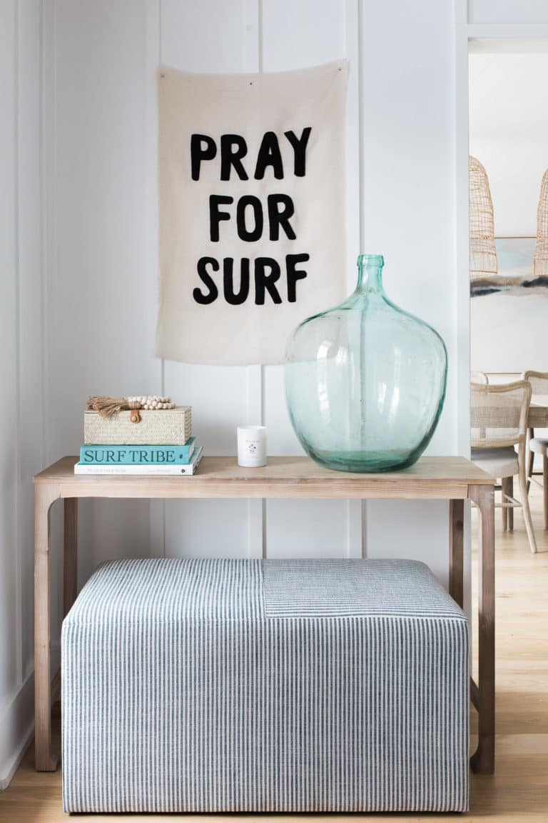 Love this beautiful modern entryway design with a light wood console table, glass vase, stool, and pray for surf sign - pure joy - entryway ideas - modern coastal style - modern coastal entryway - foyer