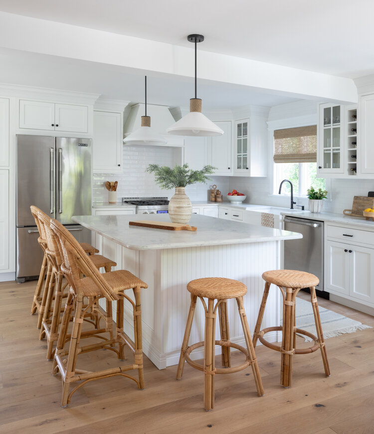 Love this beautiful all white kitchen design with woven counter stools at the island - modern kitchen ideas - white kitchen cabinets - kitchen island ideas - kitchen lighting
