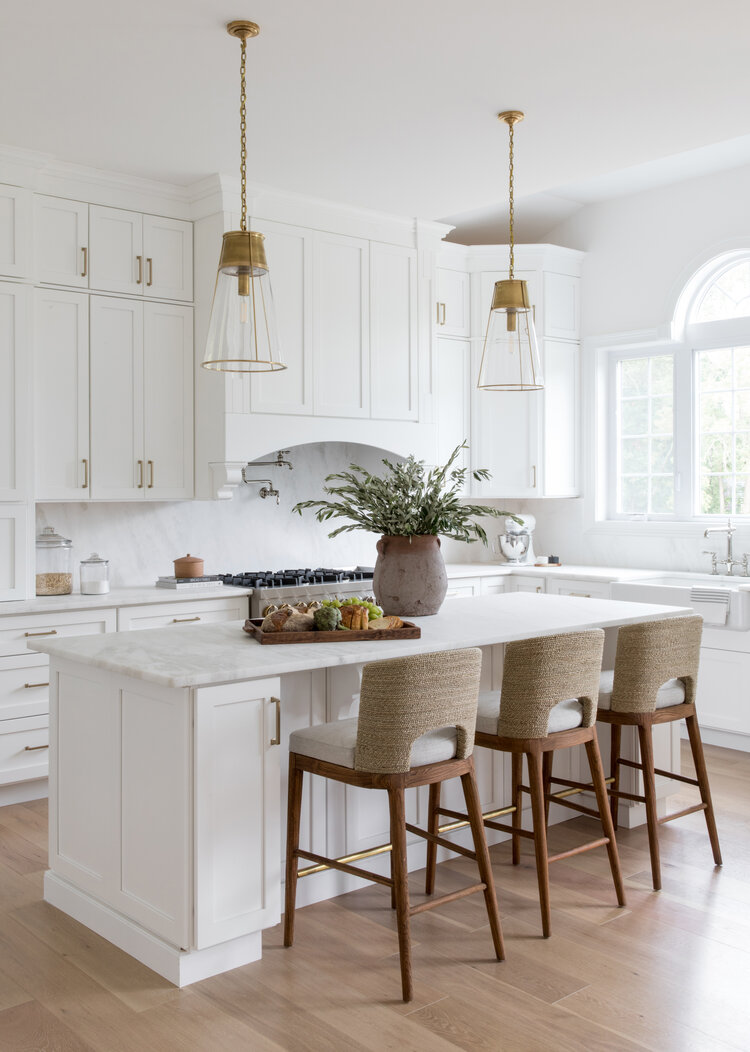 Love this classic kitchen design with white floor-to-ceiling cabinets, glass & brass pendant lights, and seagrass counter stools.  kitchen remodel - kitchen decor - white kitchen ideas - salt design