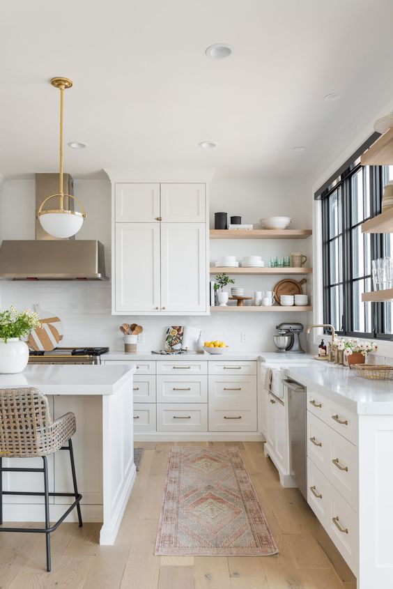 Beautiful light and airy kitchen design with lovely brass and white modern pendant lights, a white subway tile backsplash, and woven counter stools - Christine Andrew #kitchendesign #kitchenideas #kitchendecor #whitekitchen #modernkitchen 