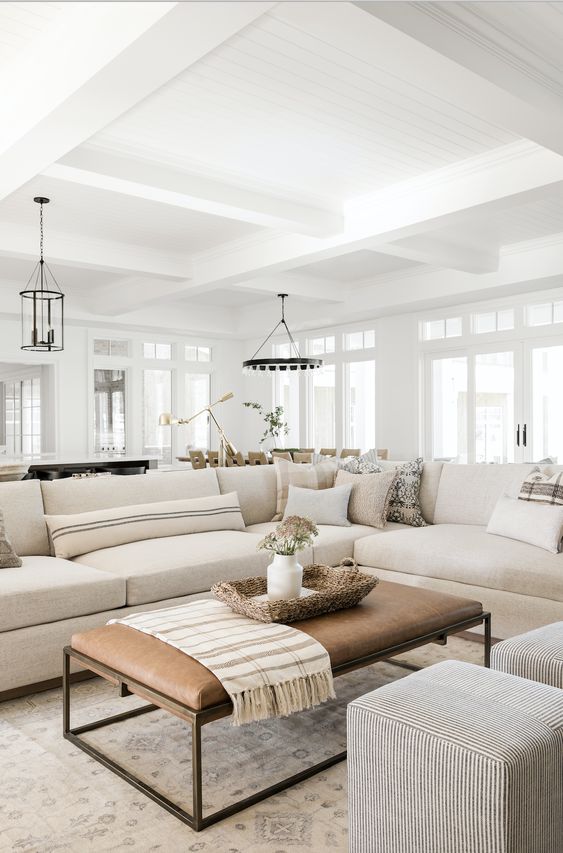 Beautiful modern living room with large white sectional and ottoman coffee table - studio mcgee
