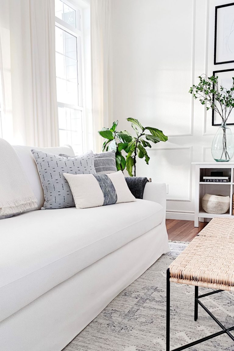 Modern coastal living room with white Ikea Farlov slipcovered sofa and round wood coffee table - jane at home