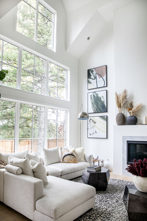 Love this beautiful modern transitional living room with vaulted ceilings, a fireplace, and warm neutral furniture and decor - trickle creek homes