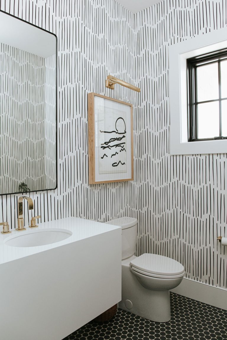 Love this chic powder room with modern wallpaper and black and brass accents - lifestyled co