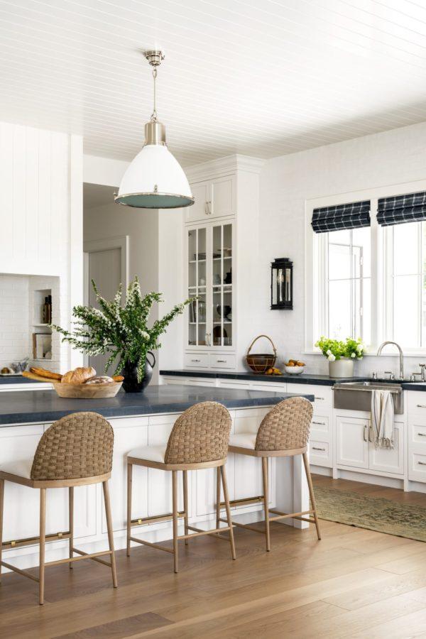Love this beautiful kitchen design featuring woven barstools, black countertops, white kitchen cabinets, and modern coastal pendant lights - kitchen ideas - black and white kitchen - kitchen cabinet ideas