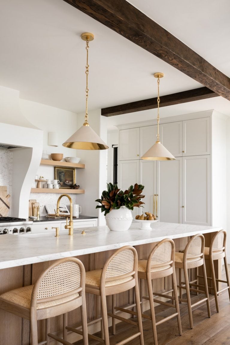 Love this stylish modern kitchen design with a light wood kitchen island, white cabinets, cane counter stools and modern cone pendant lights - kitchen makeover - modern kitchen ideas - kitchen lighting 