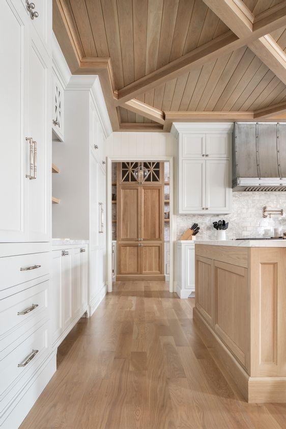 Love this beautiful white kitchen design with light oak wood ceilings islands, flooring, and cabinetry - quiet luxury - the fox group 