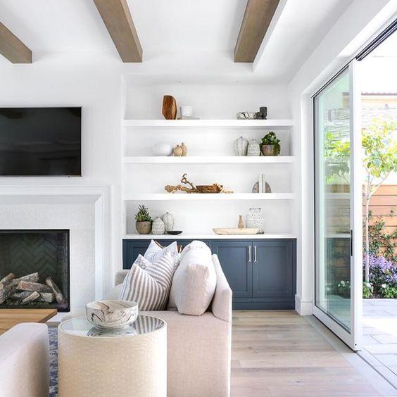 Love this beautiful living room design with wood beams, built in shelving and cabinets next to the fireplace and tv wall, and light neutral furniture and decor - lindye galloway