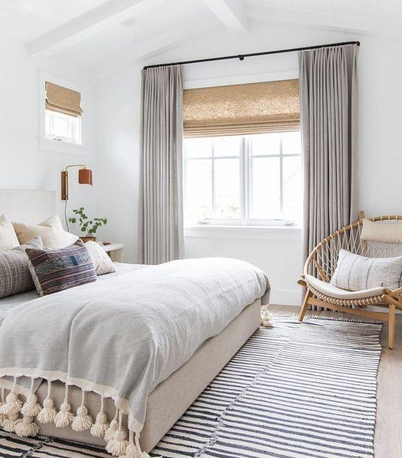 Love this beautiful bedroom design with a striped rug, circle chair, tasseled blanket and neutral decor and furniture - amber interiors