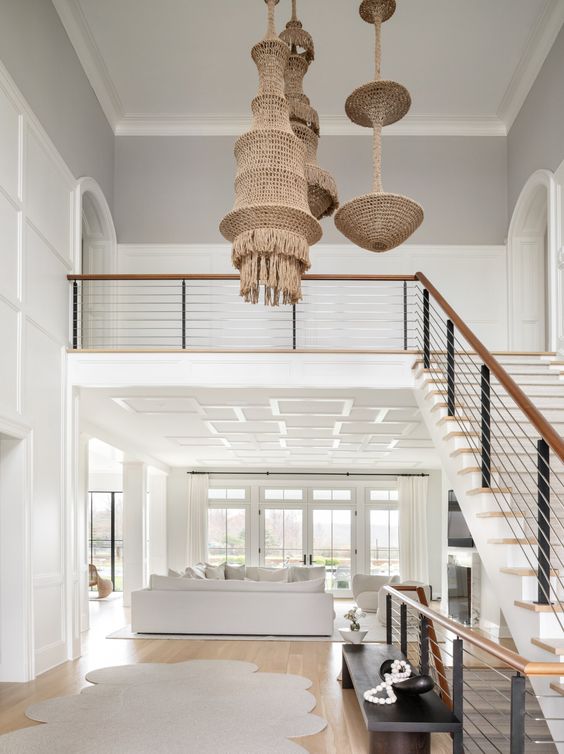 Love this beautiful entryway, staircase and living room with neutral decor and furniture, woven light fixtures, white slipcovered furniture, and a Hamptons style aesthetic - amy kalikow interior design - coastal grandmother - coastal style - nancy meyers style