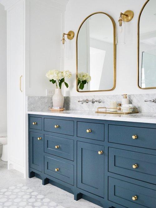 Love this beautiful modern bathroom design with a dark blue vanity, brass arched mirrors and polished nickel faucets - bathroom remodel - modern bathroom - rehabitat interiors