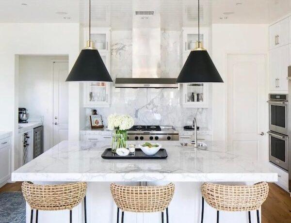 Love this beautiful kitchen design with woven counter stools, white kitchen cabinets, and black pendant lights over the kitchen island - becki owens
