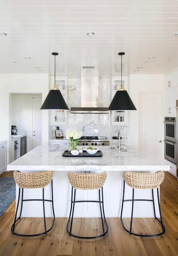 Love this beautiful kitchen design with woven counter stools, white kitchen cabinets, and black pendant lights over the kitchen island - becki owens