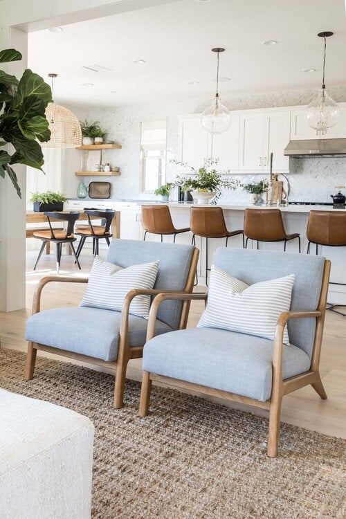 Beautiful open concept living room and kitchen withtwo mid-century modern chairs and organic modern coastal decor - Pure Salt