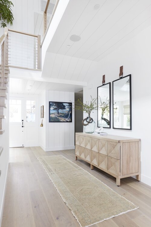 Beautiful modern beach house entryway with shiplap and light wood cabinet
