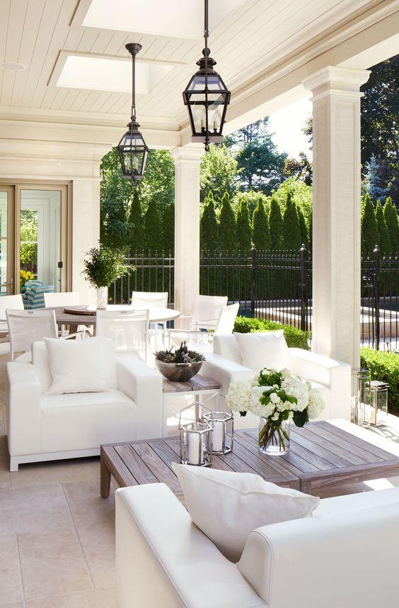 Love this beautiful covered patio and seating area with white slipcovered chairs, slate floor, black lantern pendant lights and a round dining table Architectural Digest / Virginia Macdonald Photographer Inc. #patio #outdoorideas #entertaining #space #ideas #design #entertainment #porch #yard #decor #style