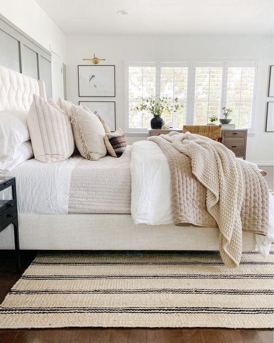 Love this beautiful modern master bedroom with neutral bedding, furniture and decor, and a striped jute rug - the heart and haven - bedroom ideas - bedroom decor - organic modern decor - coastal decor - coastal bedroom - coastal grandmother