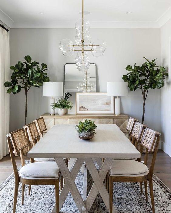 Love this beautiful transitional dining room with a wood dining table, rattan dining chairs and modern chandelier - dining room decor - transitional interior design - transitional dining room - pure salt interiors