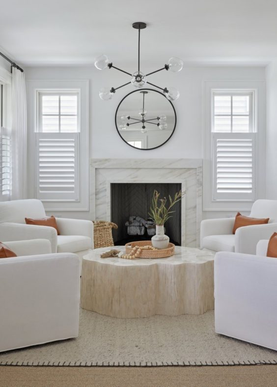 A beautiful living room featuring four white chairs around a center coffee table
