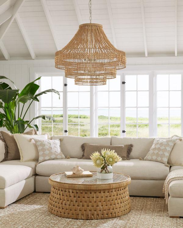 Serena & Lily sectional, round coffee table, and woven chandelier in the living room