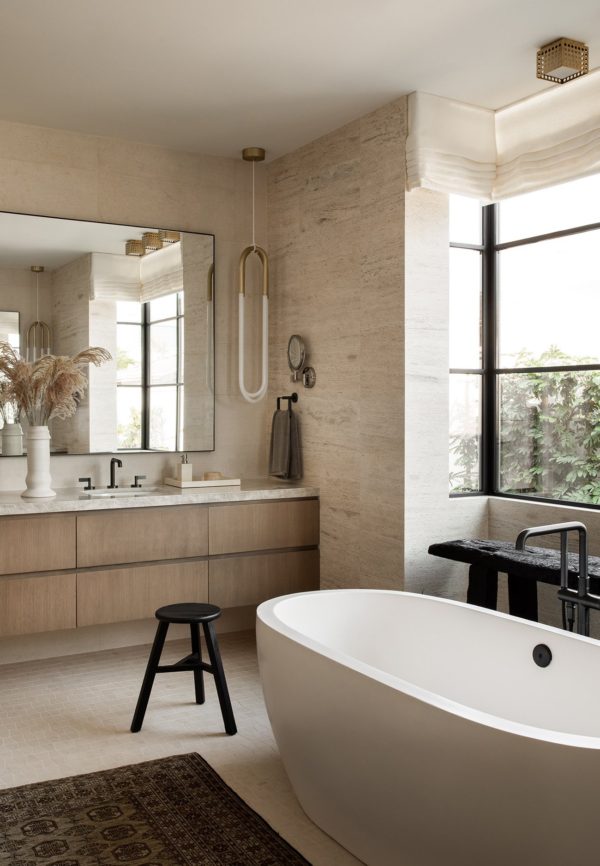 Love this beautiful modern master bathroom with warm wood vanity cabinet, stone wall treatment, and freestanding bathtub - elegant bathroom - bathroom trends 2023 - brandon architects