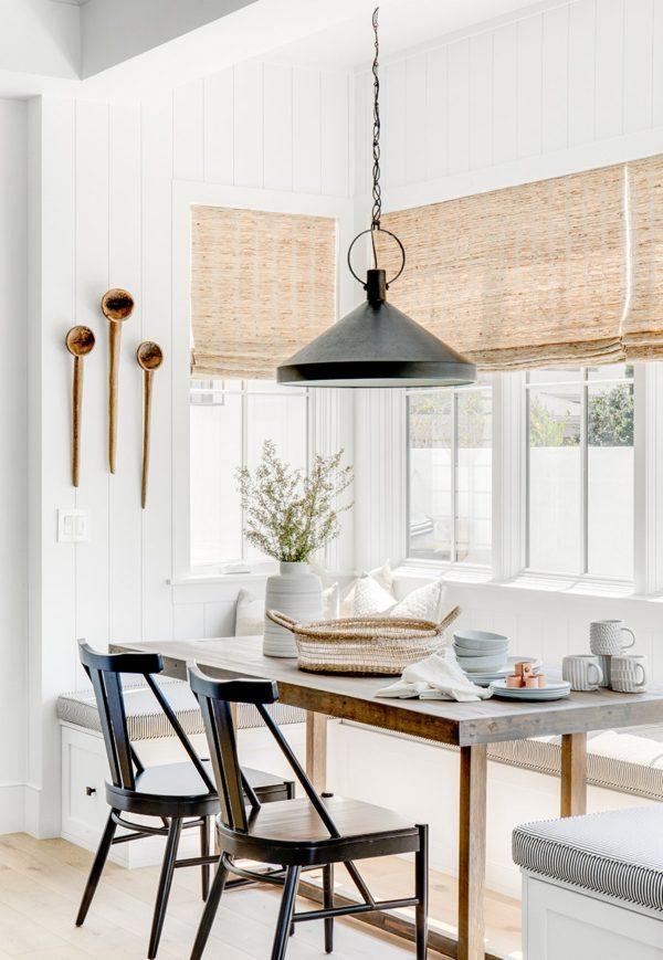 Love this beautiful modern kitchen dining area and breakfast nook with a built in bench banquette, wood dining table, black dining chairs, and black pendant light - brandon architects 