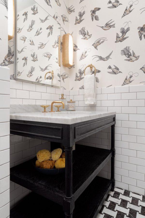 Love this beautiful powder bathroom with bird wallpaper, marble countertop, black and white tile floor - brass faucet and sconces, black vanity, and white subway tile wall treatment - bathroom ideas - small bathroom - guest bathroom - powder bath - wallpaper ideas