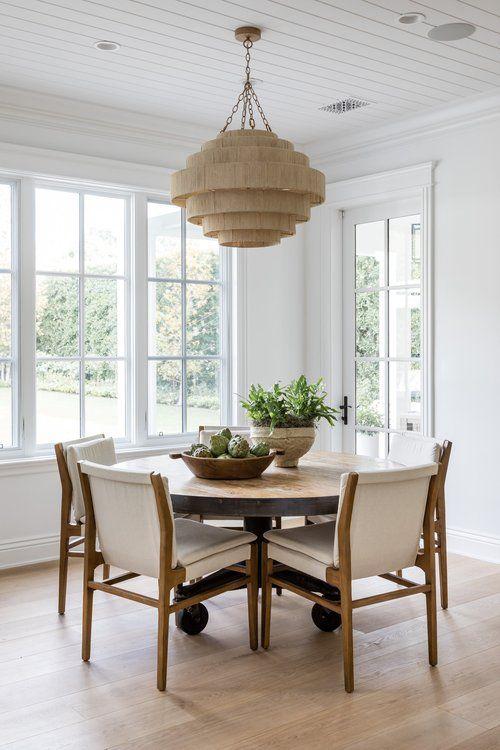 Love this beautiful dining room design with a woven pendant light fixture, round wood dining table and neutral dining chairs - dining room ideas - dining room decor - modern dining room - coastal interior design - coastal cowgirl - pure salt interiors