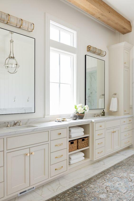Love this beautiful modern master bathroom with two sinks, neutral vanity cabinets, marble countertops, and a mix of polished nickel and brass lighting, faucets, and hardware - bathroom remodel - bathroom ideas - bathroom decor - bathroom cabinet ideas - bathroom vanity ideas