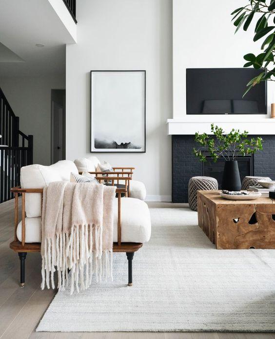 Love this beautiful modern living room design with two arm chairs a wood coffee table, black fireplace, and neutral furniture and decor - living room ideas - living room furniture - tv wall ideas - living room table - living room decor - organic modern - leclair decor