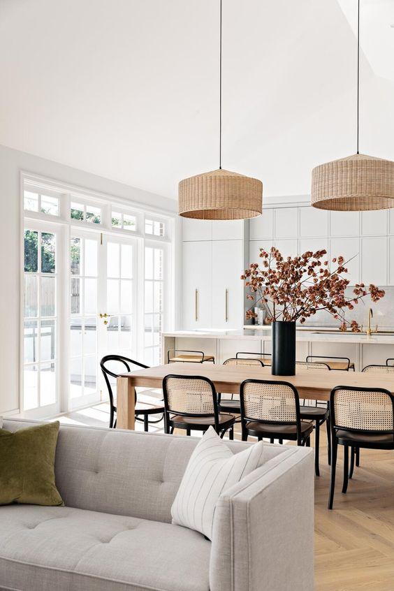 Love this beautiful open concept modern home and living area with woven pendants, black and cane dining chairs and light gray kitchen cabinets - bone made