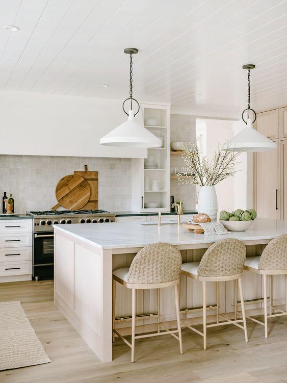 Love this beautiful modern coastal kitchen idea with a tile backsplash, modern kitchen lighting, light wood island, and woven counter stools - grayscale design