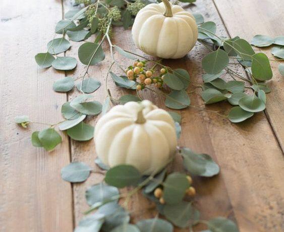 Love this beautiful thanksgiving table idea and centerpiece with tiny white pumpkins and eucalyptus as a tablescape - julie blanner
