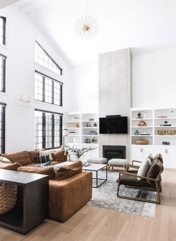 Love this beautiful modern living room design featuring a marble coffee table, vaulted ceilings, tv wall, fireplace, built-in shelves and cabinetry, leather sectional, and neutral furniture and decor - leclair decor