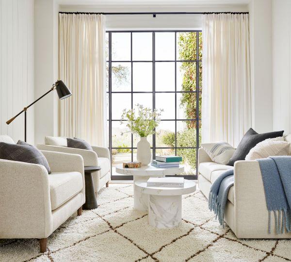 Love this beautiful transitional living room with a white sofa, two chairs, and nesting marble coffee tables - pottery barn
