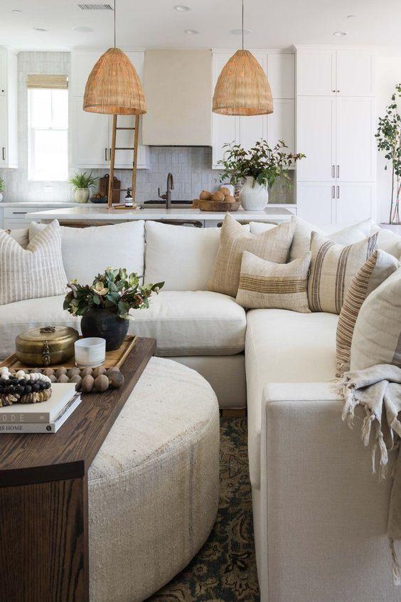Love this beautiful open concept living room and kitchen with a large sectional, round coffee table ottoman, and neutral decor and lighting - living room ideas - coastal living rooms - small cozy living room - decor home living room - coastal decor - pure salt interiors