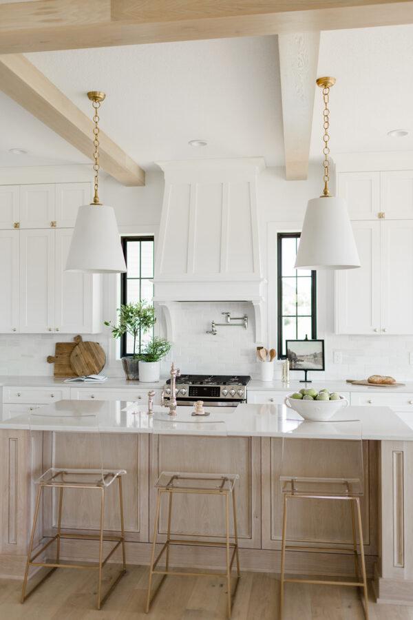 Love this timeless kitchen design with wood ceiling beams, white cabinets, and a whitewashed oak island.  The pendant lights over the island lend a modern touch to this beautiful space,