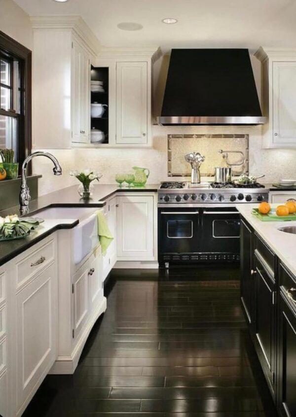 A look at the popular kitchen cabinet paint colors for 2023, plus the best white paints, how much it costs to paint cabinets, finishes, top brands, color trends, and more - love this beautiful kitchen with white cabinets black oven, countertops, windows and hood - Tyler Redman