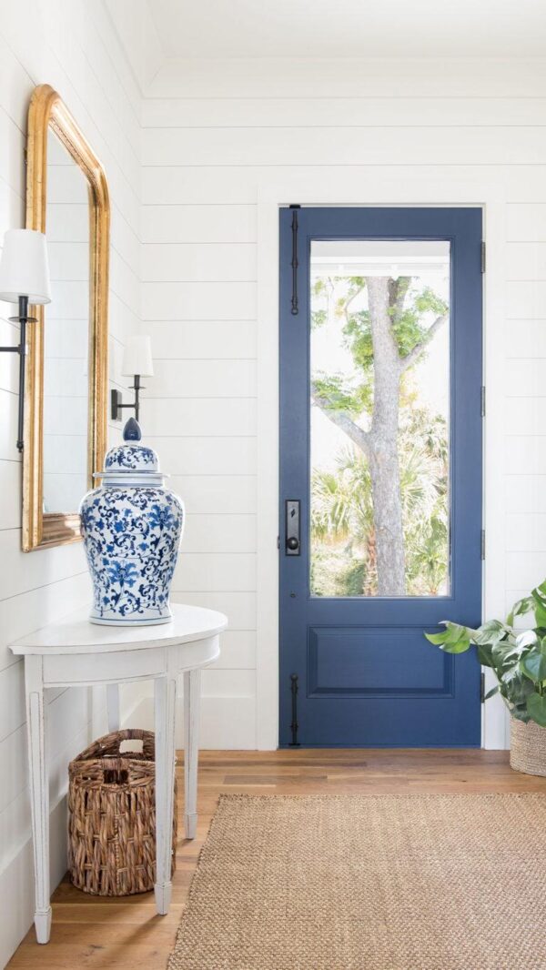Shiplap walls, a natural fiber rug, and a glorious blue door create the quintessential coastal entryway.  Barrow Building Group
