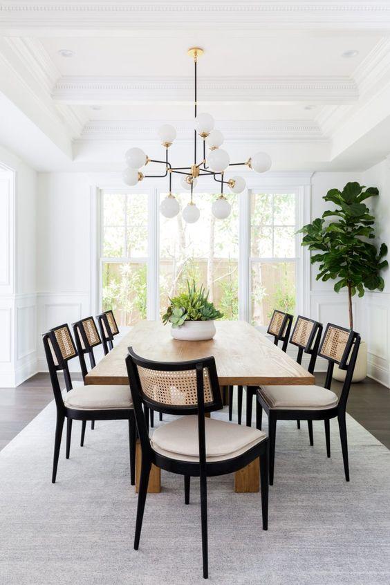 Love this beautiful modern dining room with a long wood dining table, black and cane dining chairs, and a modern pendant light - dining room ideas - dining room furniture - dining room decor - dining room lighting - modern dining rooms - lindsey brooke