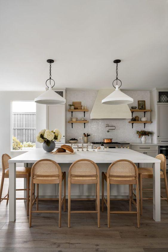 Love this beautiful modern kitchen design with blue gray island, white cabinets, rounded cane counter stools, and brass pendant lights - kitchen ideas - kitchen island ideas - kitchen cabinet ideas - coastal kitchens - kitchen lighting - kitchen counter stool ideas - modern farmhouse kitchens - studio mcgee dream makeover kitchen