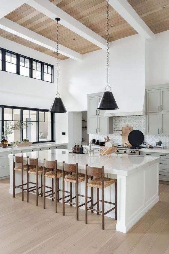 Love this beautiful modern kitchen design with a large island, woven counter stools, black pendant lights, and gray kitchen cabinets - kitchen cabinet ideas - kitchen lighting - kitchen island ideas - the life styled co