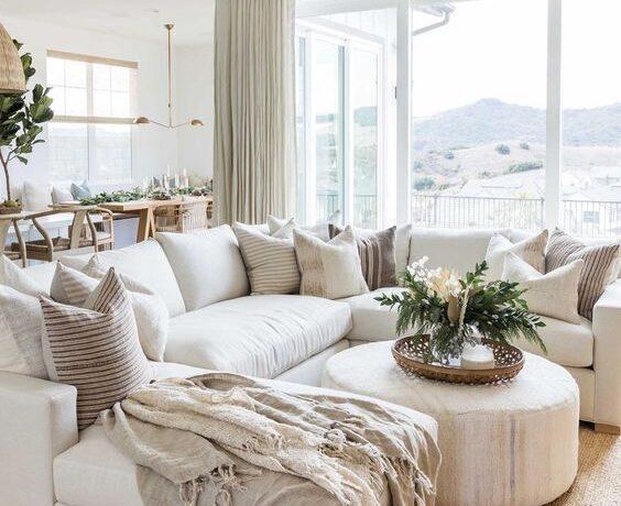 Beautiful modern living room with large white sectional, neutral decor, and leather ottoman coffee table - living room furniture - living room table - living room design - open concept living room ideas