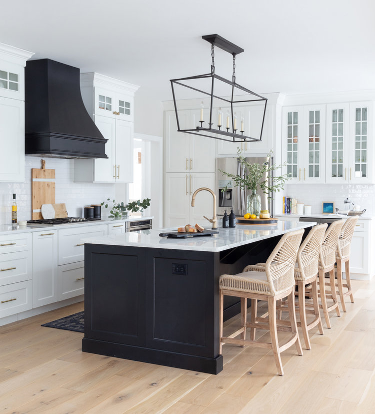 Love this chic modern farmhouse kitchen design with a black island, black range hood, and black lantern pendant light, woven counter stools, and white kitchen cabinets - stephanie kraus - kitchen ideas - kitchen remodel - kitchen island ideas - kitchen cabinet ideas - two toned kitchen